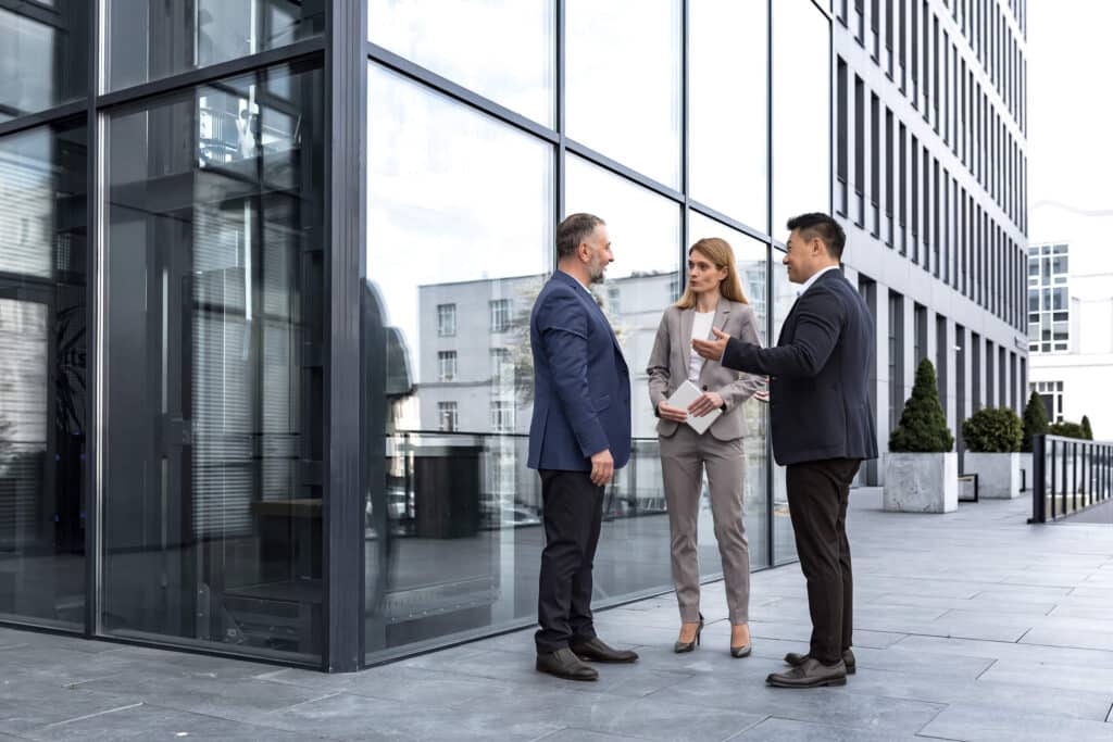 Managers discussing commercial fire risk assessment outside building