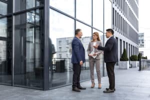 Managers discussing commercial fire risk assessment outside building