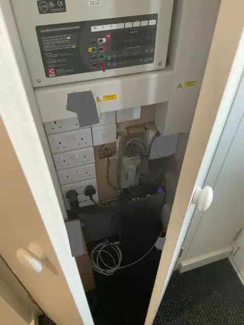 The service cupboard housing the fire alarm panel, meter and electrical equipment.