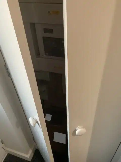 The existing cupboard shown with its doors partly open.