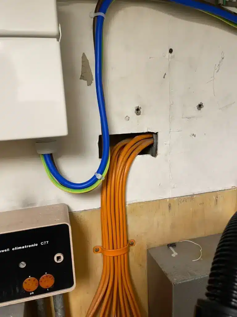 Wall lining opening around electrical cables.