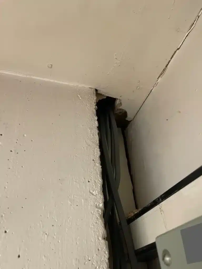 Cabling and a visible gap at the wall and ceiling junction.